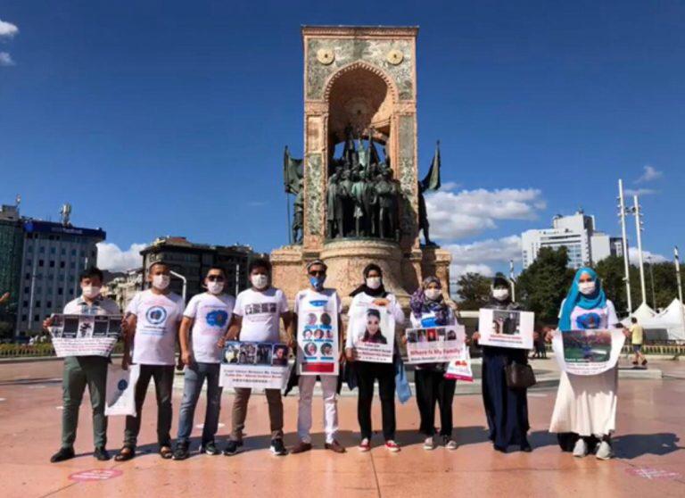 Uiguren tragen T Shirts mit Fotos von ihren Familienangehörigen 